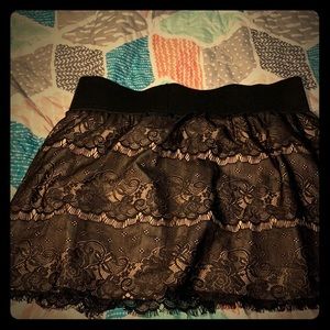 A black and cream colored floral lace skirt.